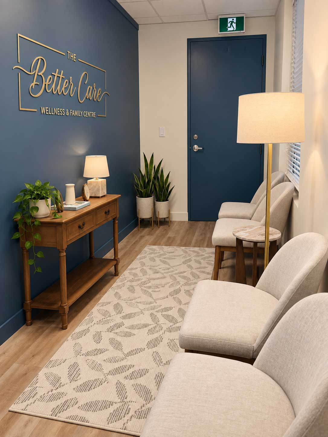 The reception area of The Better Care Family Centre, with a navy blue wall, the Better Care logo in gold, a wooden console table and a row of upholstered chairs